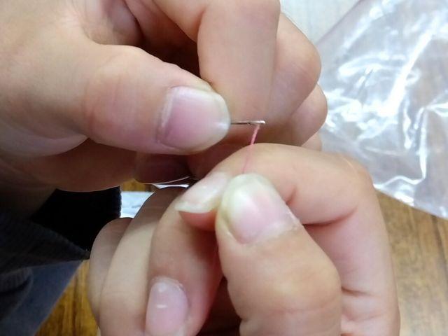 指導員と子どもたちが一緒に裁縫をしている様子